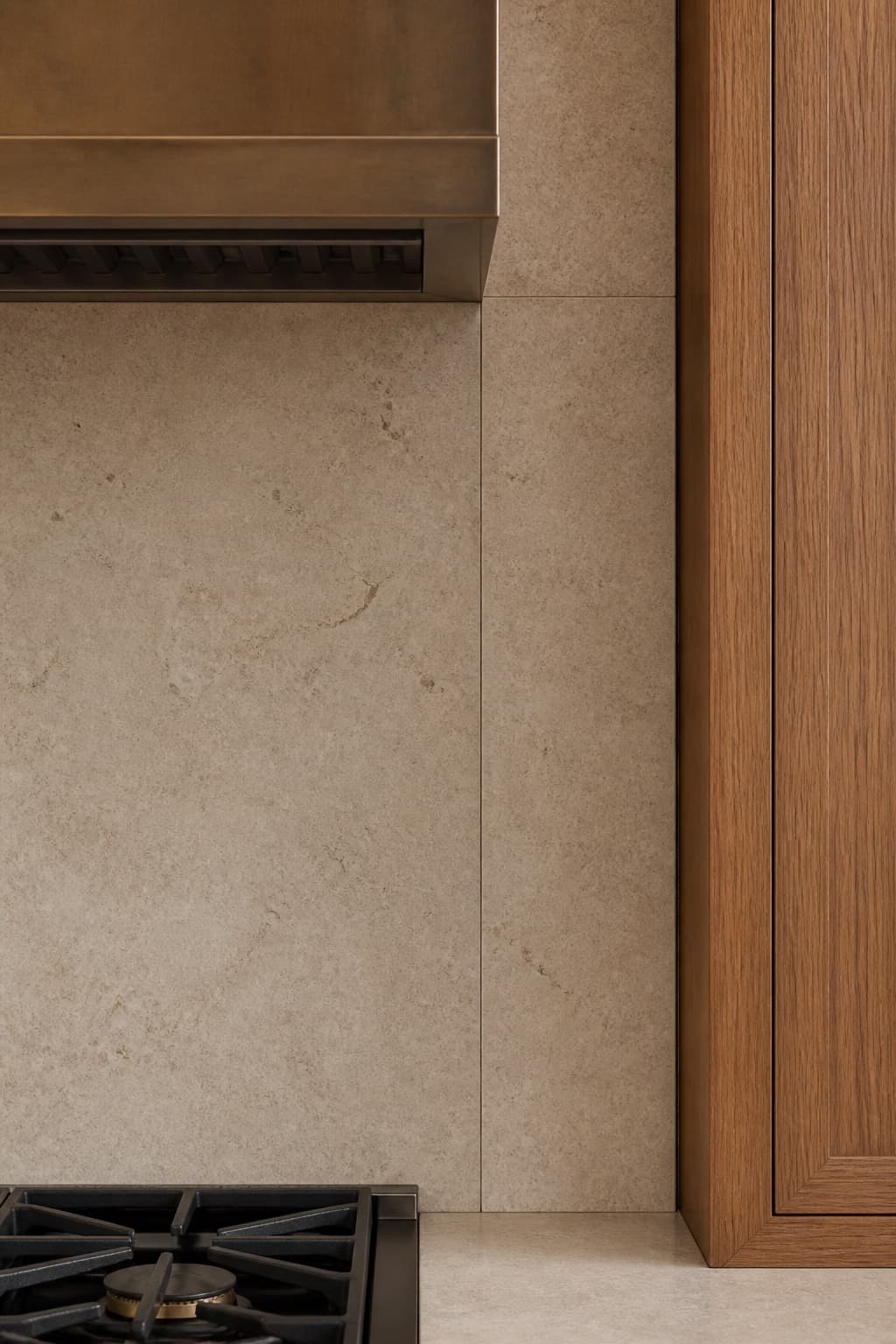 The backsplash meeting the range hood with a clean scribed cut